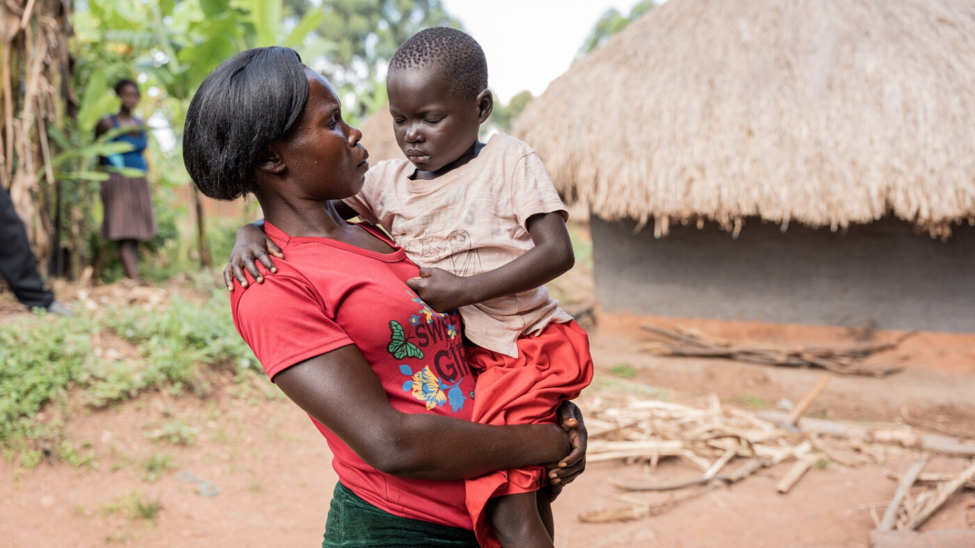 Fosca holds her daughter, Happy, who has her eyes closed due to the pain of trachoma.