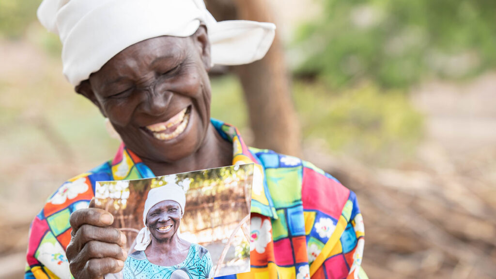 Angeshita grins while holding an old photo of herself.