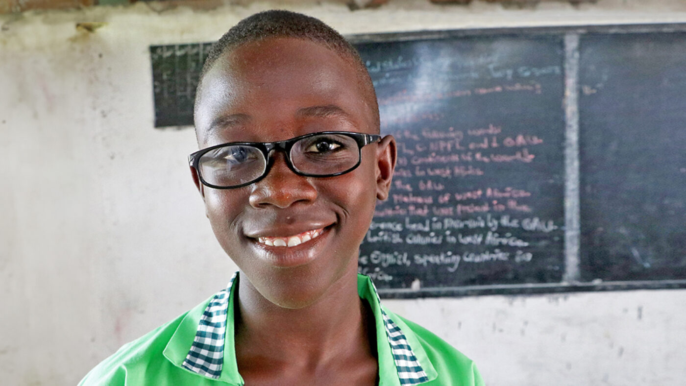 Arthur smiles in the classroom while wearing his new spectacles.