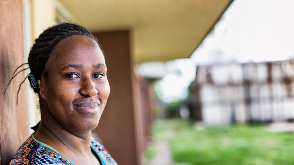 Melanie, who has a hearing impairment, stands outside a building where she's attending a networking course.