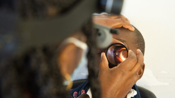 Joseph's eye being checked by one of the clinic staff
