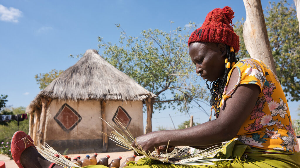 Maria weaving baskets outside her home in Zimbabwe. She was able to return to work after a successful operation for advanced trachoma.