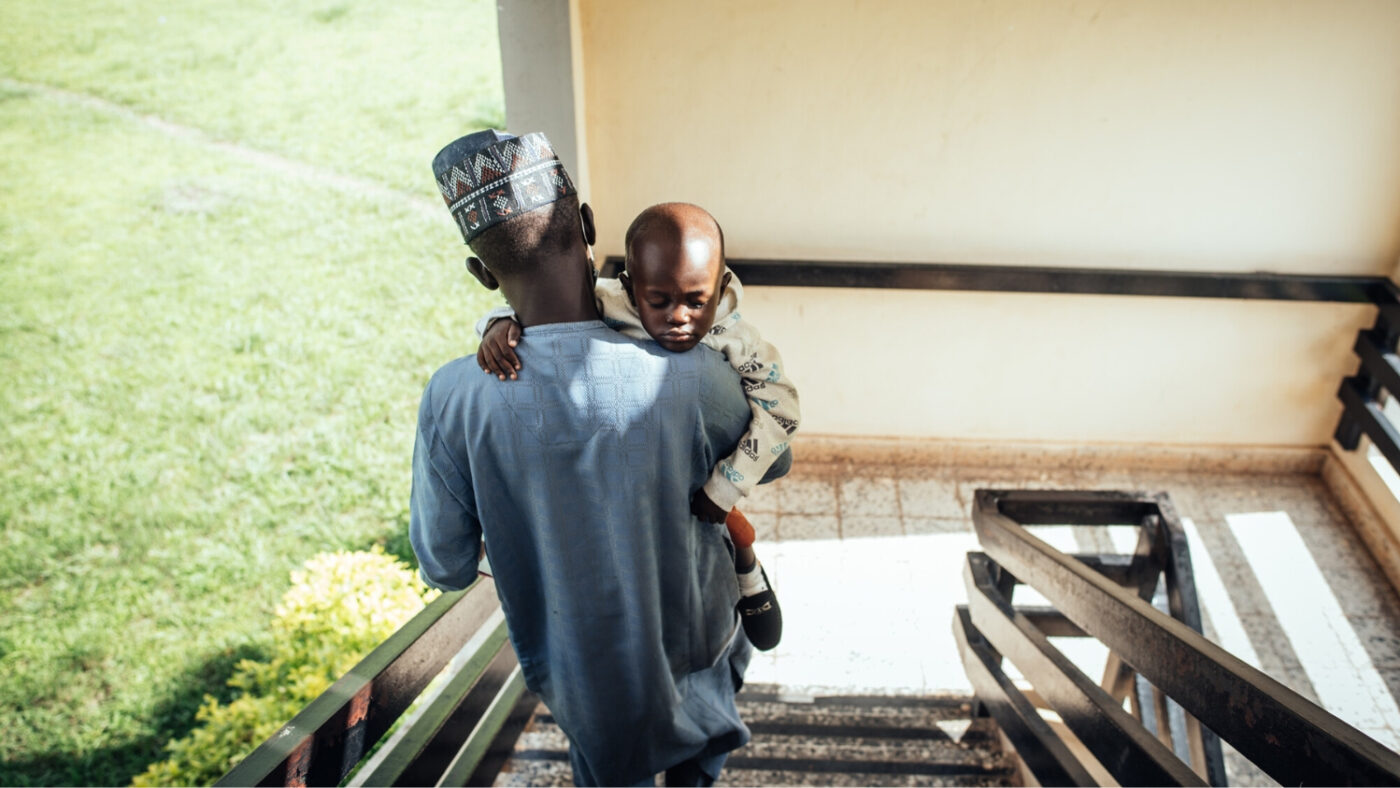 Abubakar carries Muhammad down a set of stairs at the National Eye Centre in Kaduna, Nigeria.