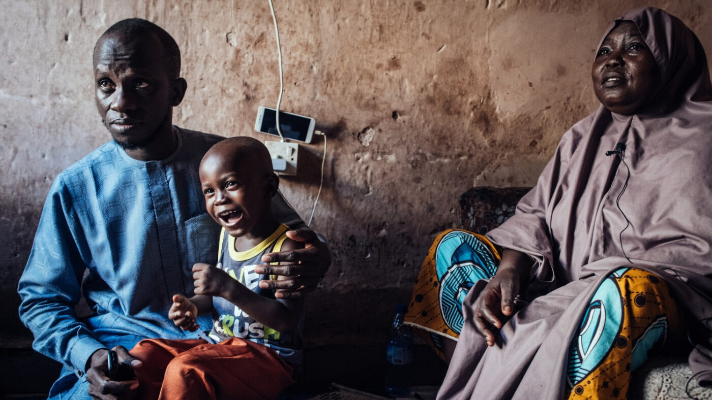 Muhammad sits with his father and grandmother at home the day after his cataract operation.