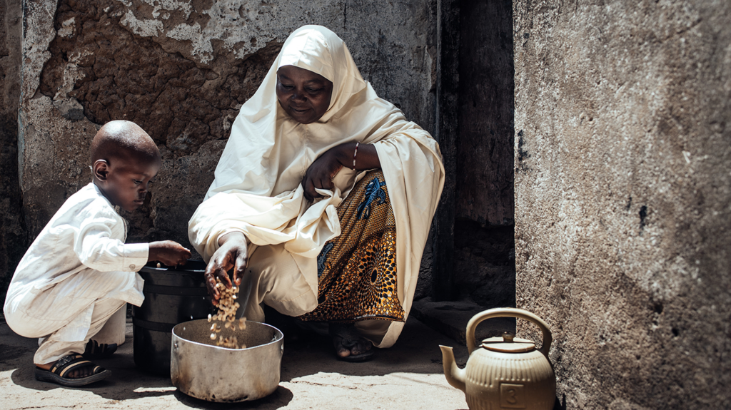 Muhammad and his grandmother, sat outside prepping food to cook.