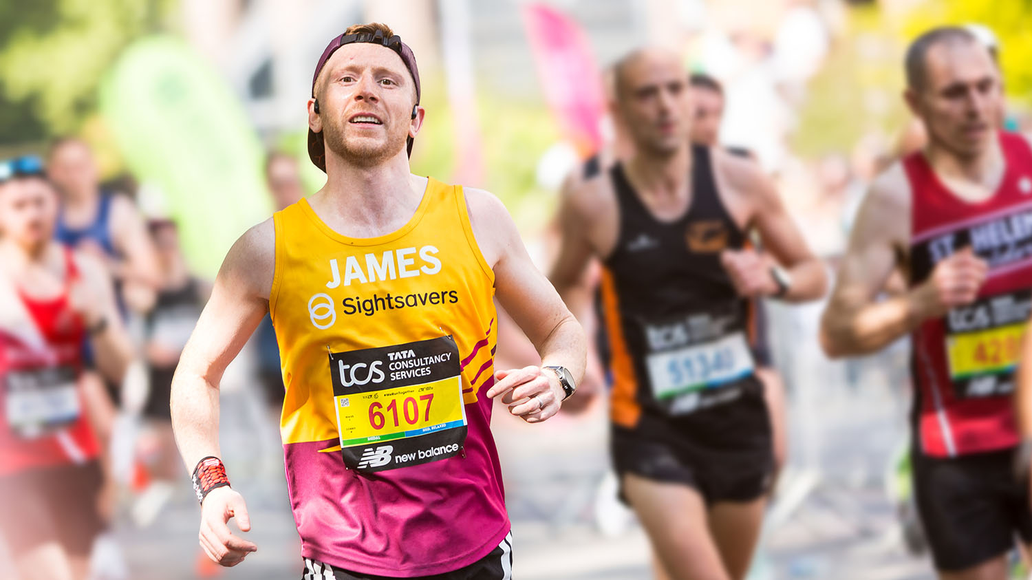 James running the 2025 London Marathon. He is wearing a Sightsavers running vest with his name on the front.