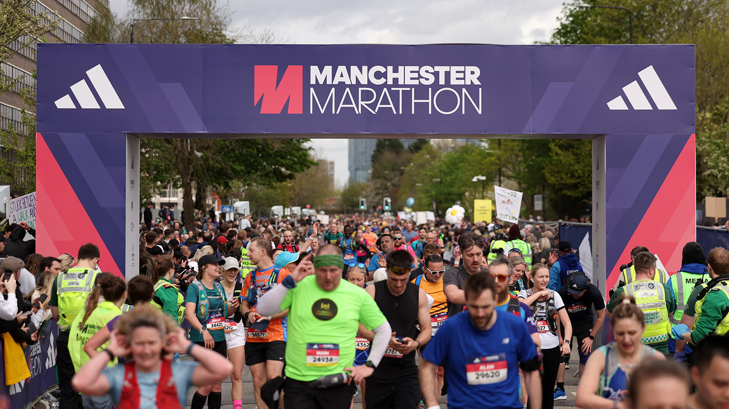A large crowd of runners and supporters at the finish line of the Manchester Marathon.
