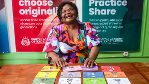 A woman smiles as she sits behind a desk with colourful cards.