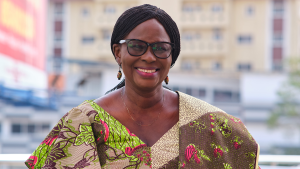 A woman with glasses smiles broadly.