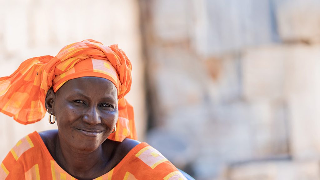 A woman wearing an orange checked headwrap.