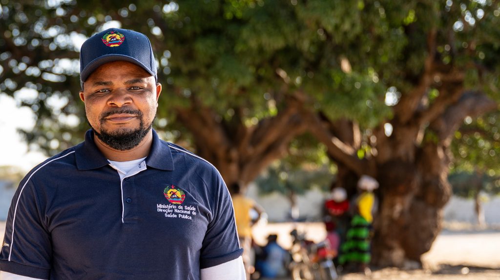 Henis wearing a baseball cap and polo shirt with branding for the Mozambique Ministry of Health.